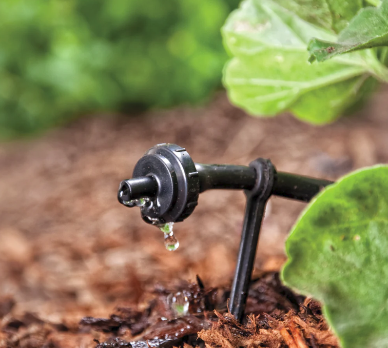 نمای نزدیک از دریپر یا قطرهچکان در سیستم آبیاری قطرهای گلخانه